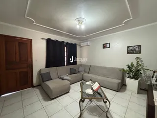 Sala de estar com sofá e piso cerâmico.