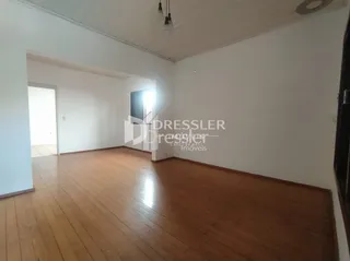 Ambiente interno com piso de madeira e paredes brancas.
