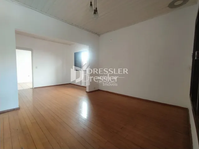 Ambiente interno com piso de madeira e paredes brancas.