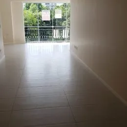 Hall de entrada longo com piso claro e vista para o exterior.