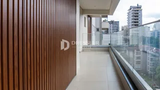 Vista de um ambiente moderno com painéis de madeira e guarda-corpo de vidro.
