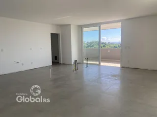 Ambiente interno amplo com piso de concreto e porta de vidro abrindo para o exterior.