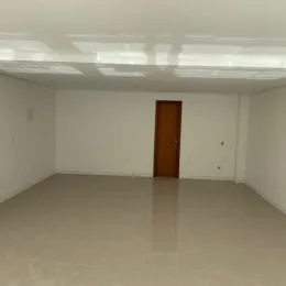 Foto de um cômodo interno vazio com paredes brancas e teto.
