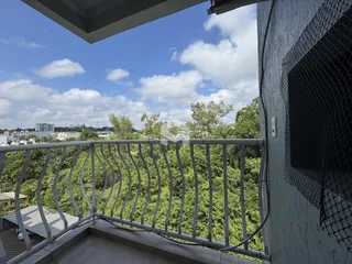 Vista da varanda com paisagem verde exuberante.
