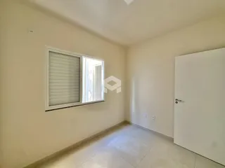 Ambiente interno de uma sala com piso de cerâmica e janela.