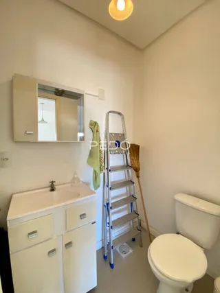 Foto de um banheiro interno com pia e vaso sanitário.