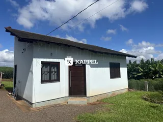 Fachada de uma casa simples branca com telhado escuro em Lajeado.