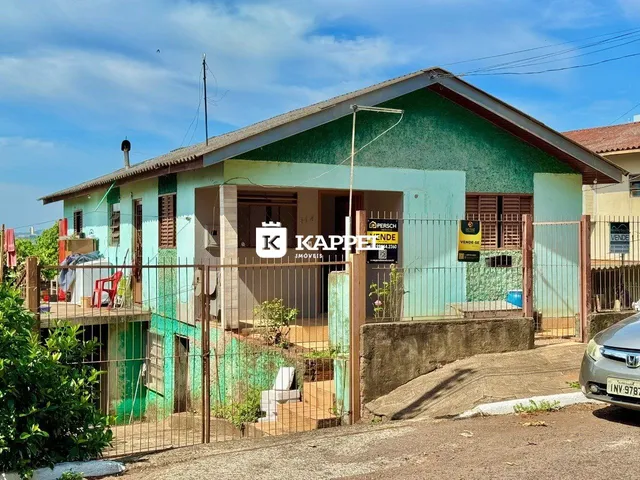 Fachada externa de uma casa em Lajeado, Brasil, com cerca de metal verde.