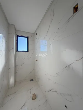 Interior de um corredor com paredes em mármore branco.