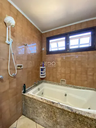 Foto de um banheiro com banheira e revestimento de azulejos.