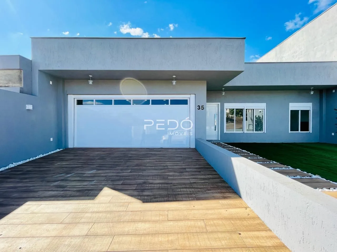 Fachada moderna de uma residência com garagem e jardim em Lajeado.