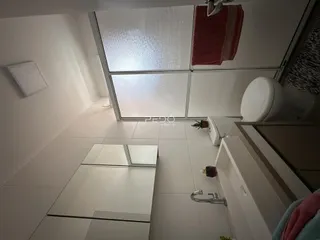 Ambiente interno de um banheiro com piso de cerâmica e revestimento branco.