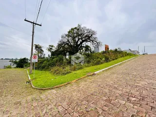 Vista da propriedade com gramado e estrada de paralelepípedos.