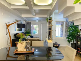 Sala de estar com móveis e iluminação clara em um apartamento.