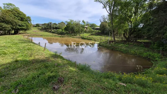 Paisagem de campo com água e vegetação ao redor.