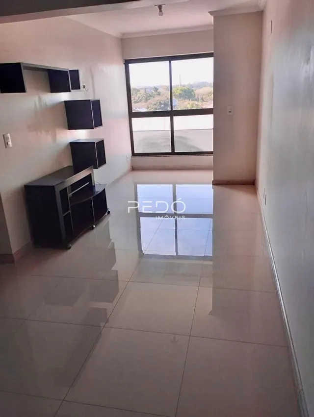 Interior de uma sala com piso de cerâmica e grande janela.