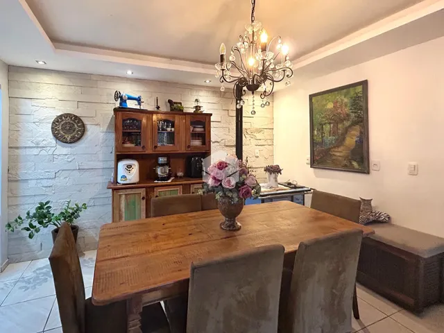 Uma sala de jantar com mesa de madeira e armário na parede.