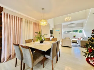 Sala de jantar e estar com piso de madeira clara.
