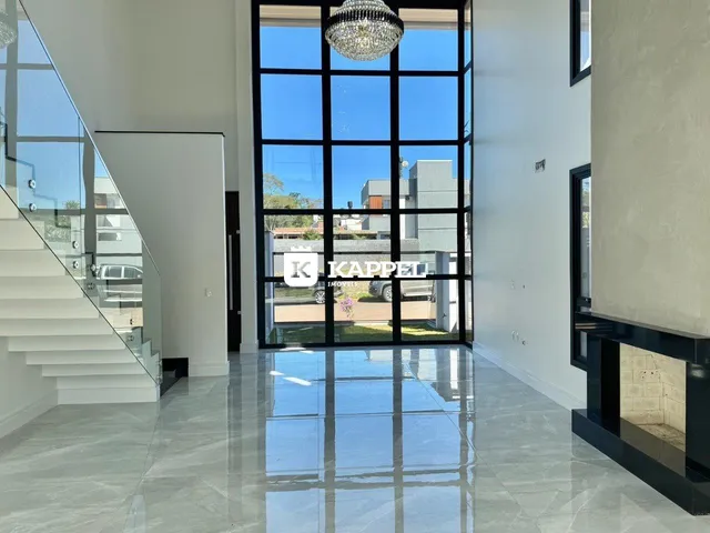 Sala de estar moderna com piso de porcelanato e grandes janelas de vidro.