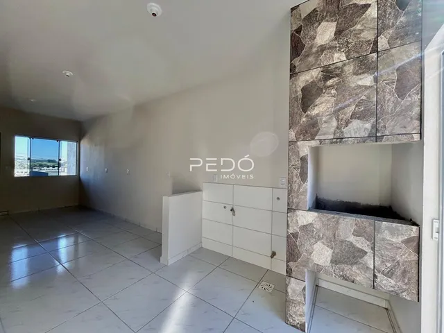 Interior de uma sala ampla com piso de cerâmica e parede de destaque em pedra.