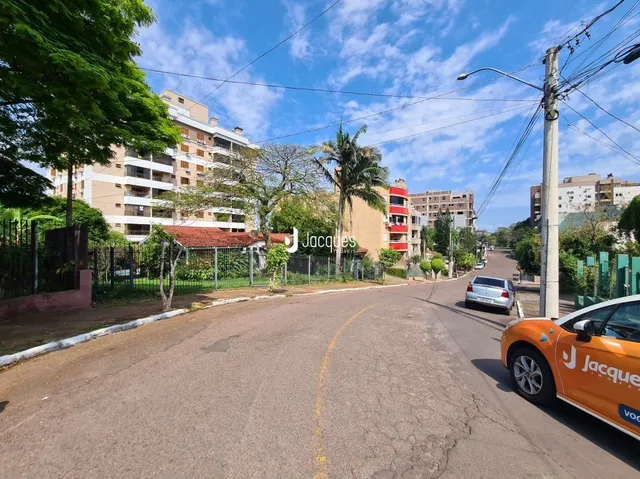 Vista da rua em Lajeado, Brasil, com árvores e casas ao fundo.
