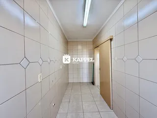 Foto de um corredor interno com revestimento de azulejos claros.