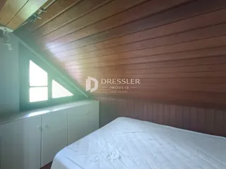 Quarto com paredes de madeira e janela.