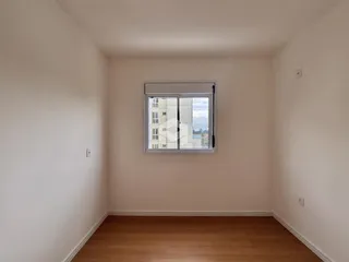 Ambiente interno de uma sala com piso de madeira e janela.