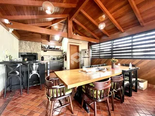 Sala de jantar com piso de tijolo e forro de madeira em uma residência.