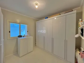 Quarto com armários embutidos brancos e piso de cerâmica.