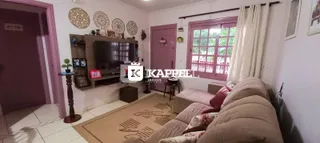 Sala de estar com sofá e televisão em ambiente claro.