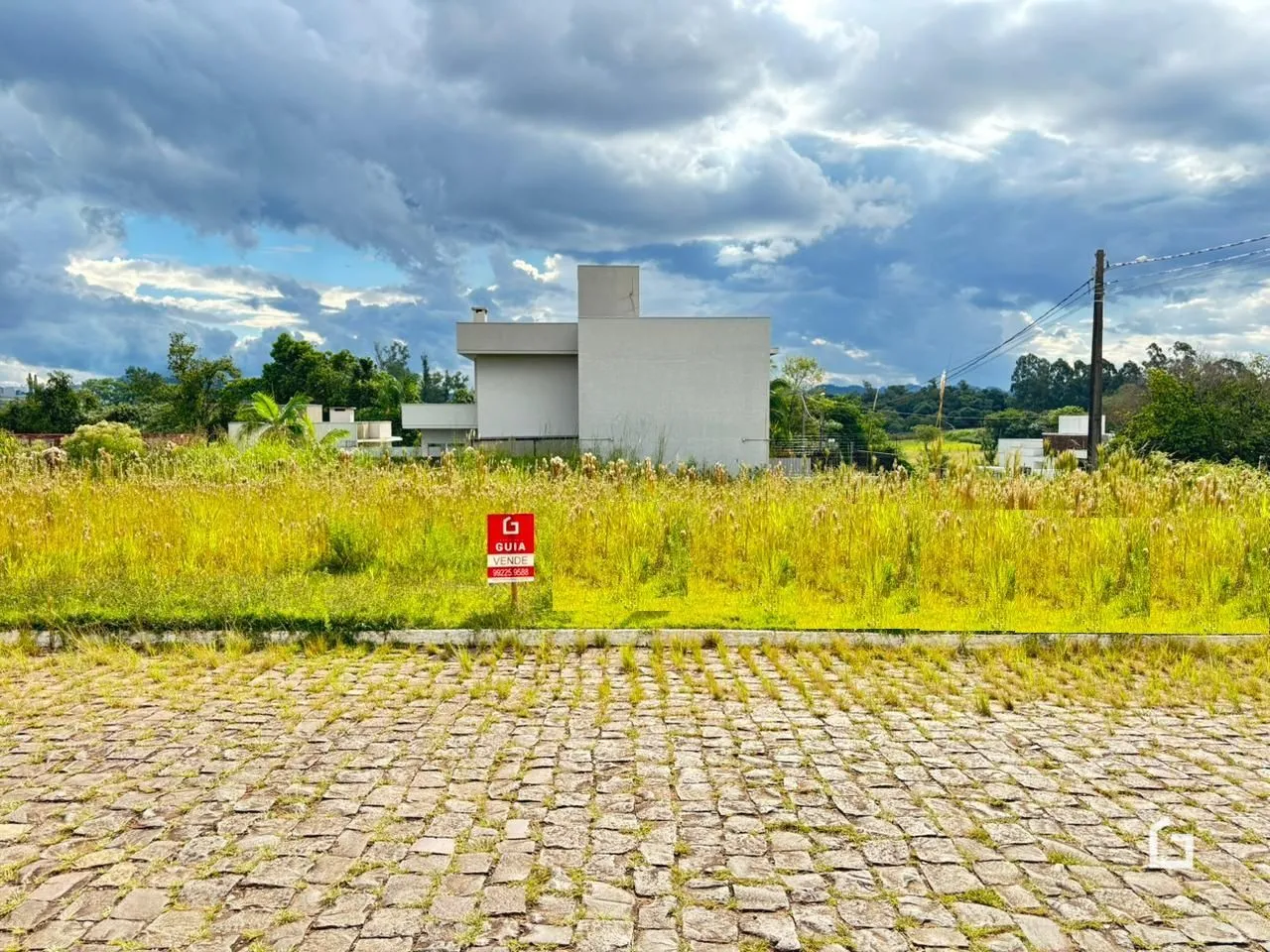 Vista externa de uma residência em Lajeado, Brasil, cercada por grama alta e uma área pavimentada.