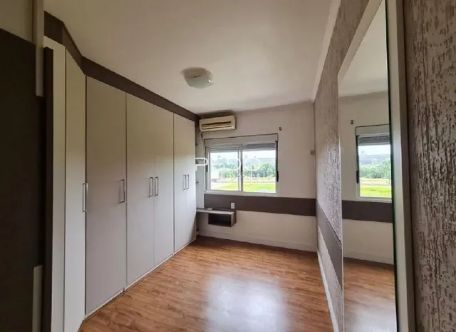 Quarto com armários embutidos e piso de madeira em um imóvel em Lajeado.