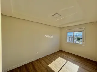 Ambiente interno de uma sala com piso de madeira e janela.
