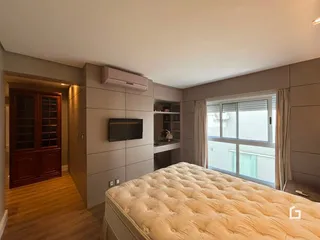 Quarto com cama e porta de madeira em um imóvel no Brasil.