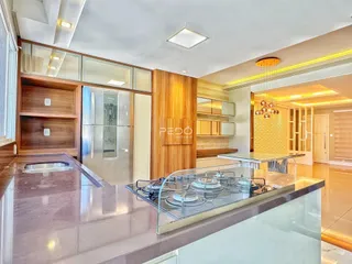 Vista da cozinha moderna com armários de madeira e bancada de granito.