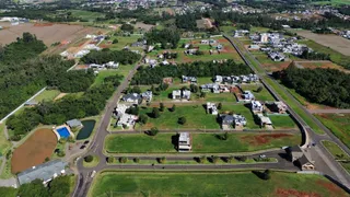 Vista aérea de uma área residencial com casas e campos verdes em Lajeado.