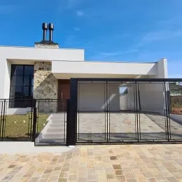 Fachada externa de uma residência em Lajeado, Brasil, com portão de metal.