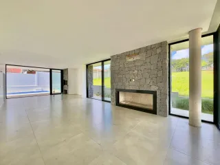 Ambiente amplo com piso claro e acesso a uma área externa com piscina.