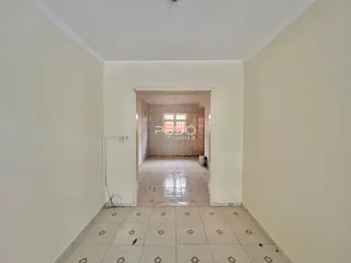 Corredor interno de uma residência com piso de cerâmica clara.
