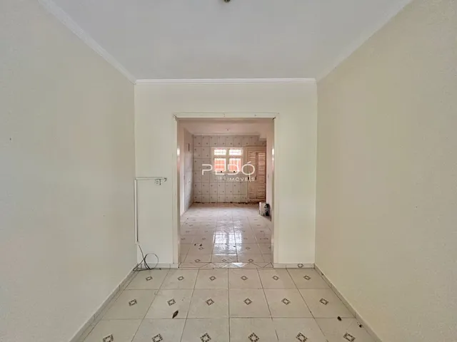 Corredor interno de uma residência com piso de cerâmica clara.