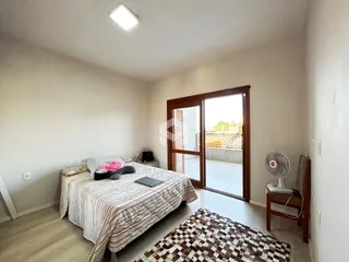 Quarto com cama e porta de vidro que oferece uma vista externa.