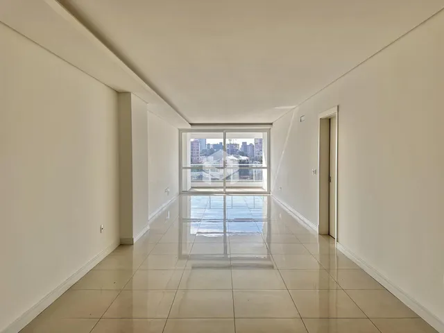 Corredor interno de um imóvel com piso de cerâmica e grande janela.