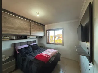 Quarto com cama e armários de madeira na sala.