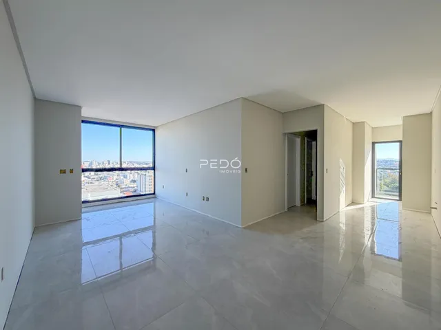 Interior de uma sala ampla com vista para a cidade.