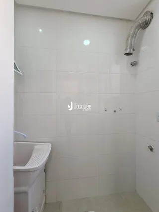 Foto de um banheiro com revestimento branco.