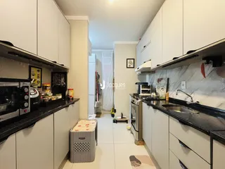 Foto de uma cozinha moderna com armários brancos e bancadas escuras.