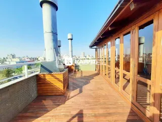 Varanda de madeira com piso de deck e vista para a paisagem urbana.