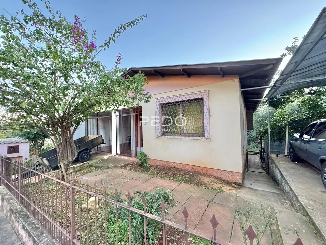 Fachada de uma casa em Lajeado, Brasil, com cerca e vegetação no primeiro plano.