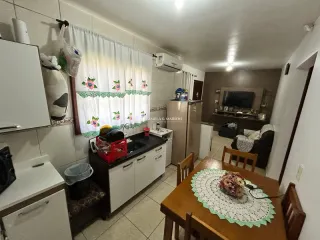 Foto de um ambiente interno com mesa de madeira e revestimento de parede de azulejos brancos.